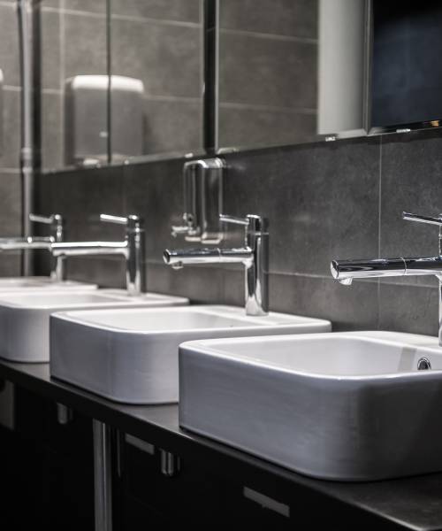Interior of a modern public bathroom toilet in grey colors.