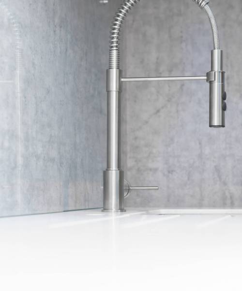 Minimalistic modern kitchen interior, faucet and sink side view close-up. Selective focus.